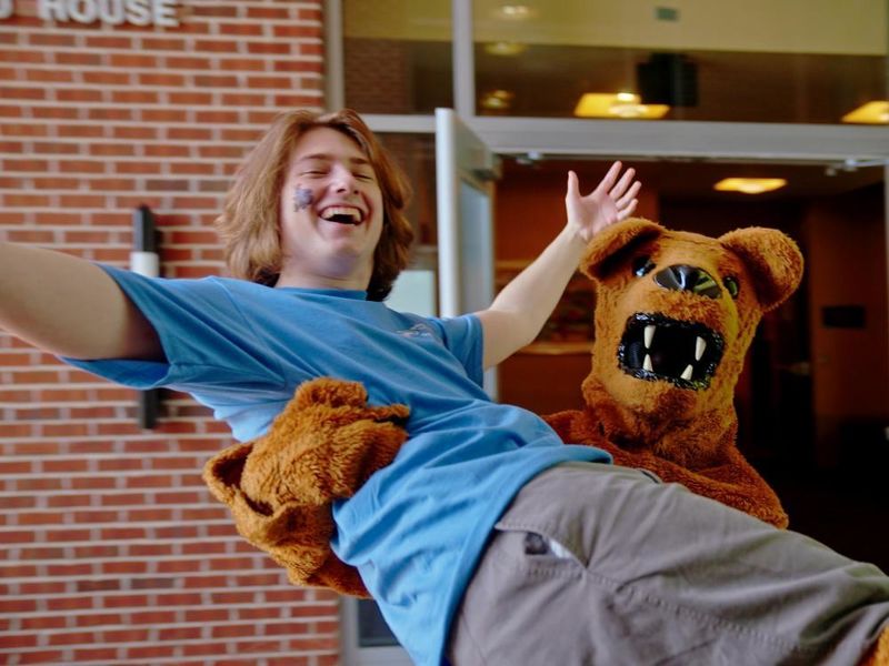 Nittany Lion mascot holds a student in his arms