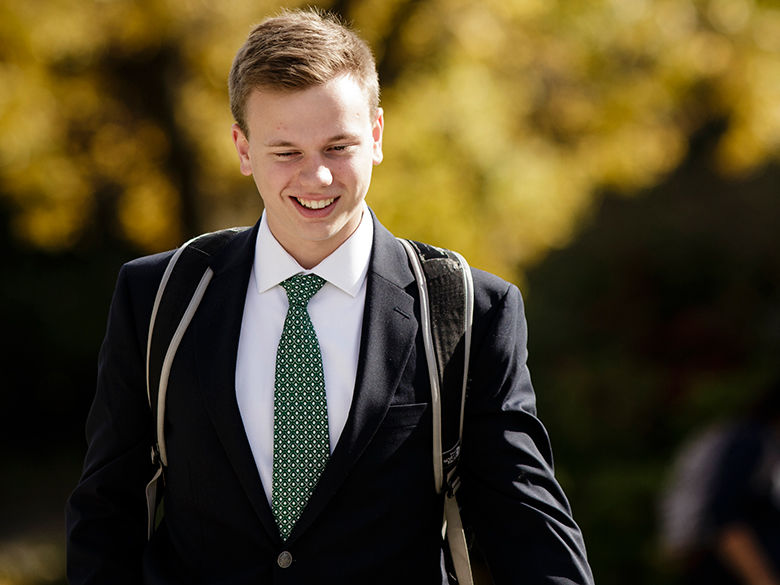 Student dressed in a suit on campus