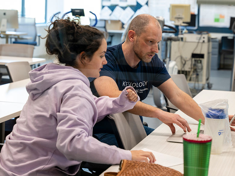 Kinesiology faculty member reviews data on laptop with student