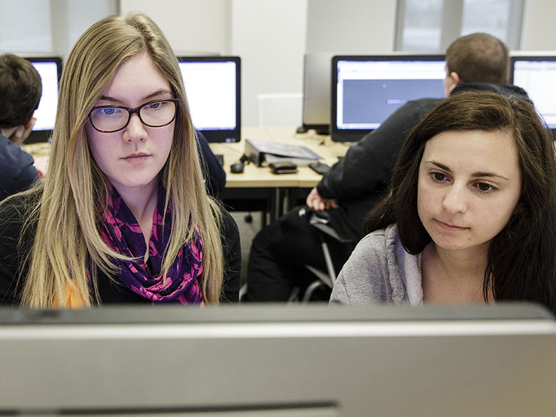 Two students working together in a computer lab