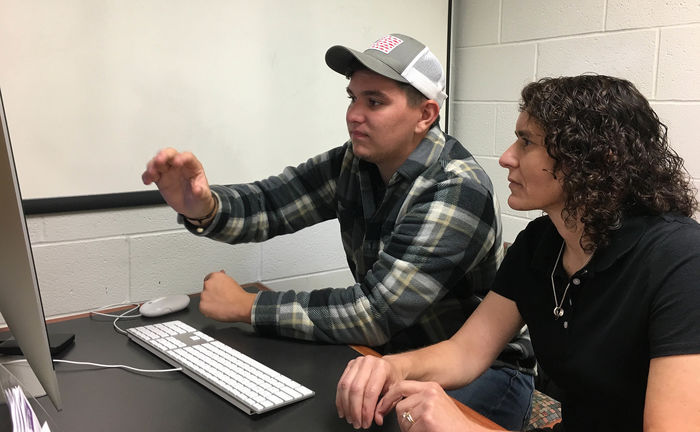 Wyatt Ritchie shows work on computer to Marietta Scanlon