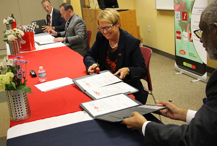 The leaders of RACC and Penn State Berks sign the agreement