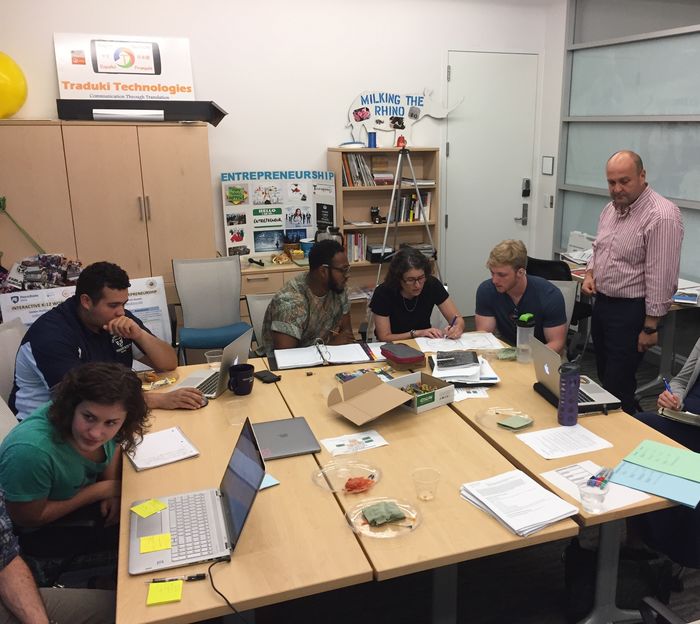 Students working together around a table in the Flemming CEED Center