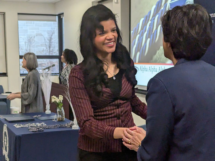 Smiling student shakes Chancellor's hand