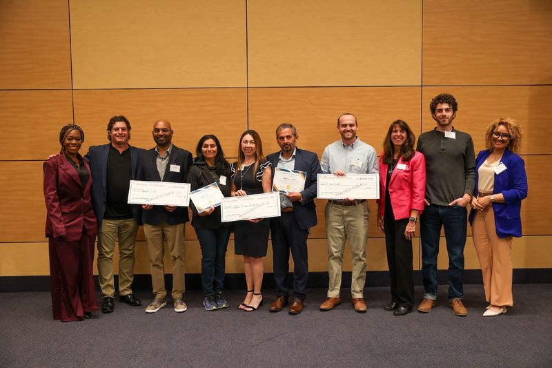 contestants holding large checks