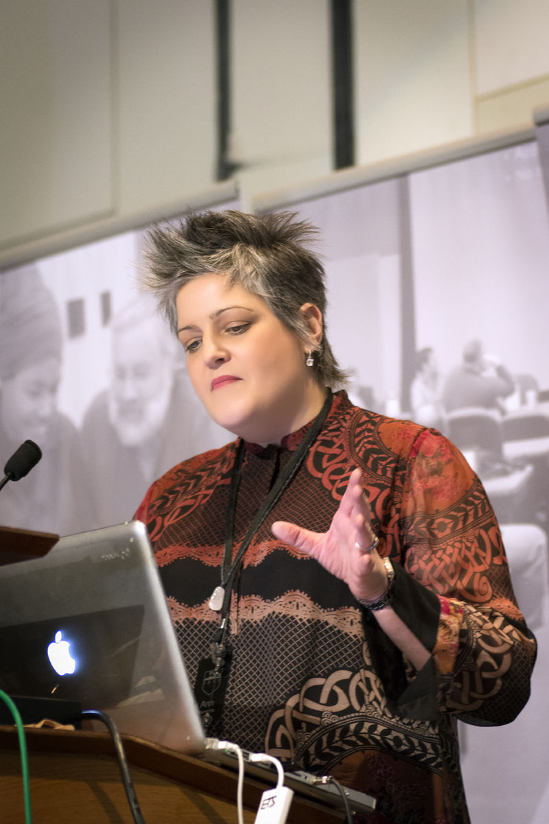 Ann Clements gestures while looking at laptop during Open Innovation Challenge