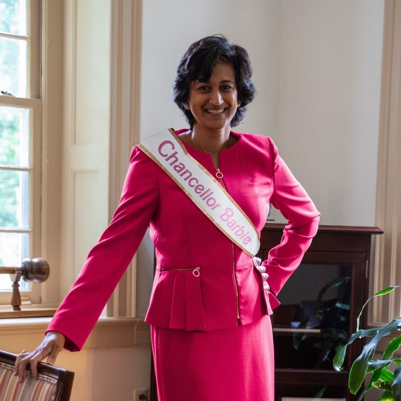 Radha Pyati wears a pink power suit with a ribbon reading "Chancellor Barbie"