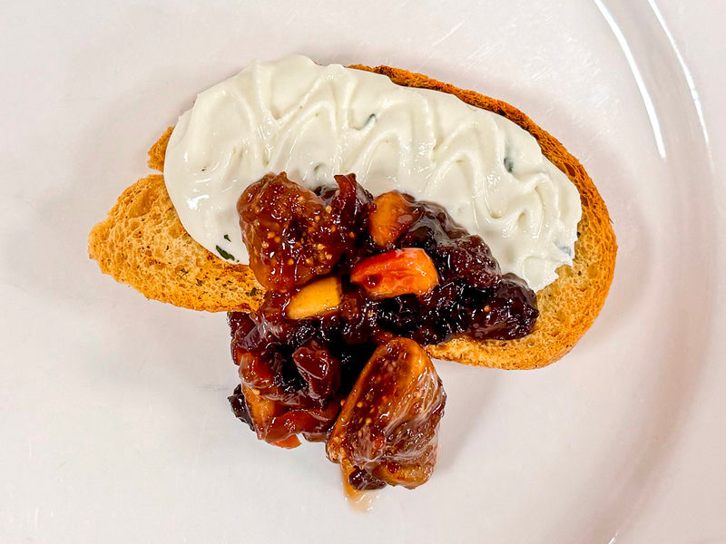 Photograph of crostini with a goat cheese and fig chutney topping