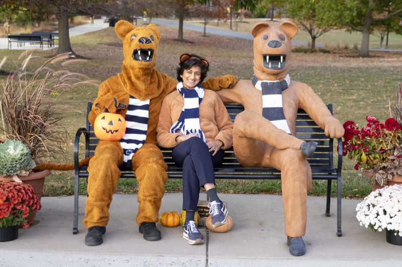 Three Nittany Lions seated on a bench