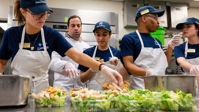 Berks students work in a food serve environment preparing salads as part of a hospitality management course