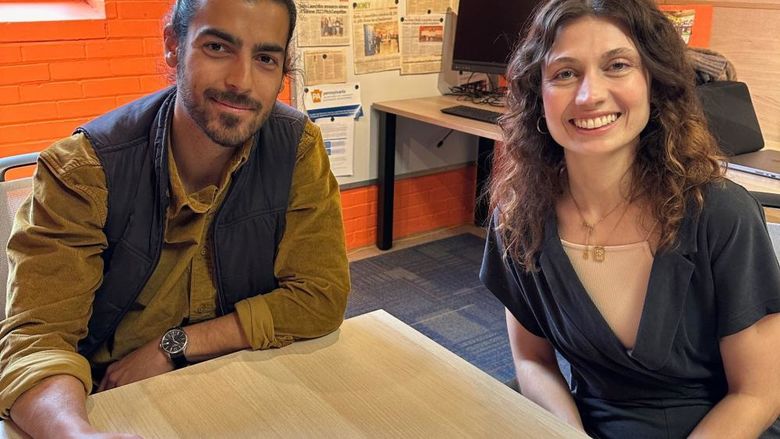 Two people sitting at a table and facing the camera