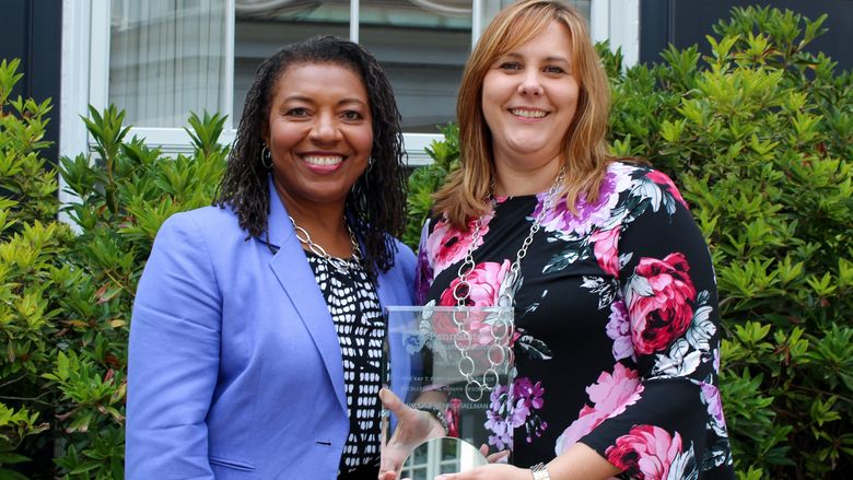 Lorraine Goff standing next to Valerie Henne-Hallman, holding her award. 