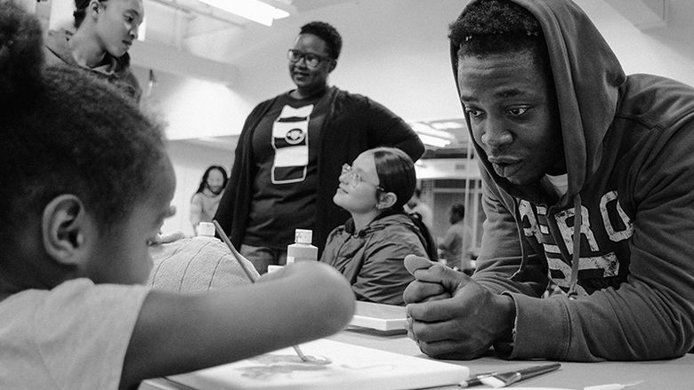 Criminal Justice Students works with youth on painting skills.