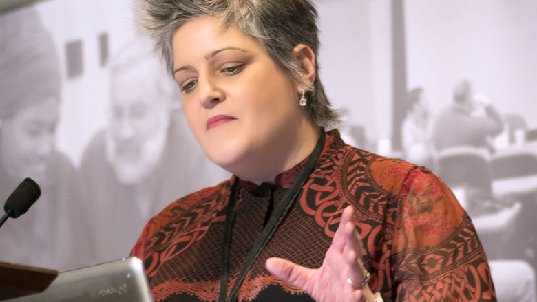 Ann Clements gestures while looking at laptop during Open Innovation Challenge