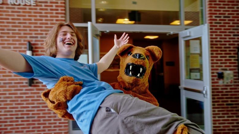 Nittany Lion mascot holds a student in his arms
