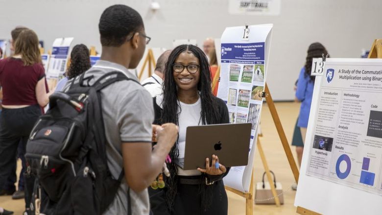 Students presenting research in poster session
