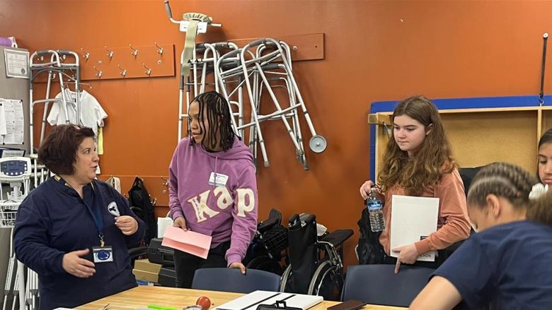 An instructor works in an occupational therapy classroom with students