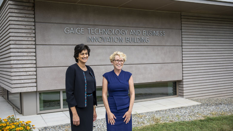 Chancellor Pyati and Rep. Houlahan pose in front of the Gaige Technology and Business Innovation Building sign
