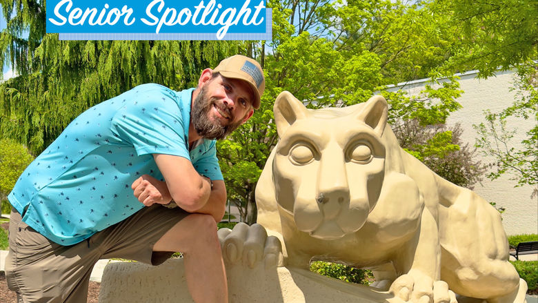 Kevin Michaels smiling when posing next to Lion Shrine