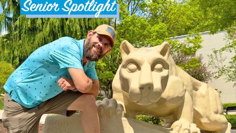 Kevin Michaels smiling when posing next to Lion Shrine