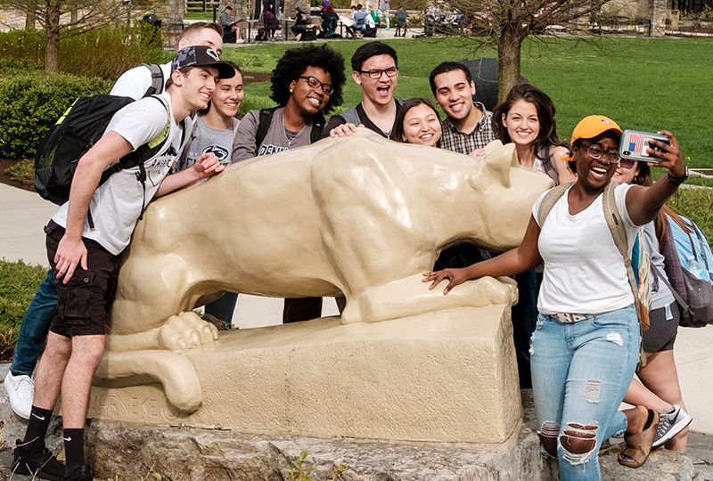Students taking a selfie in front of the lion shrine. Students taking a selfie in front of the lion shrine.