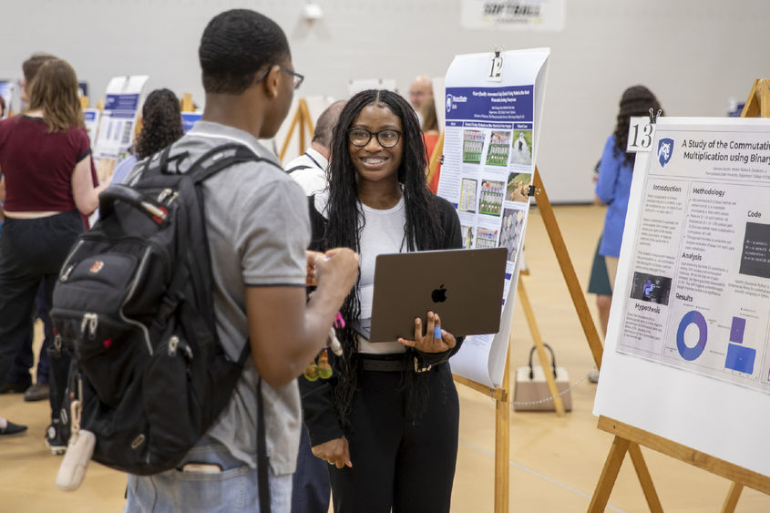 Students presenting research in poster session