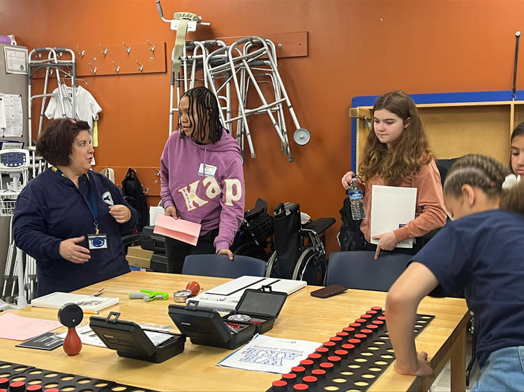 An instructor works in an occupational therapy classroom with students