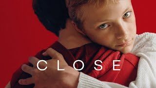 Two people hugging, with one looking at the camera. "CLOSE" is overlaid on the image.